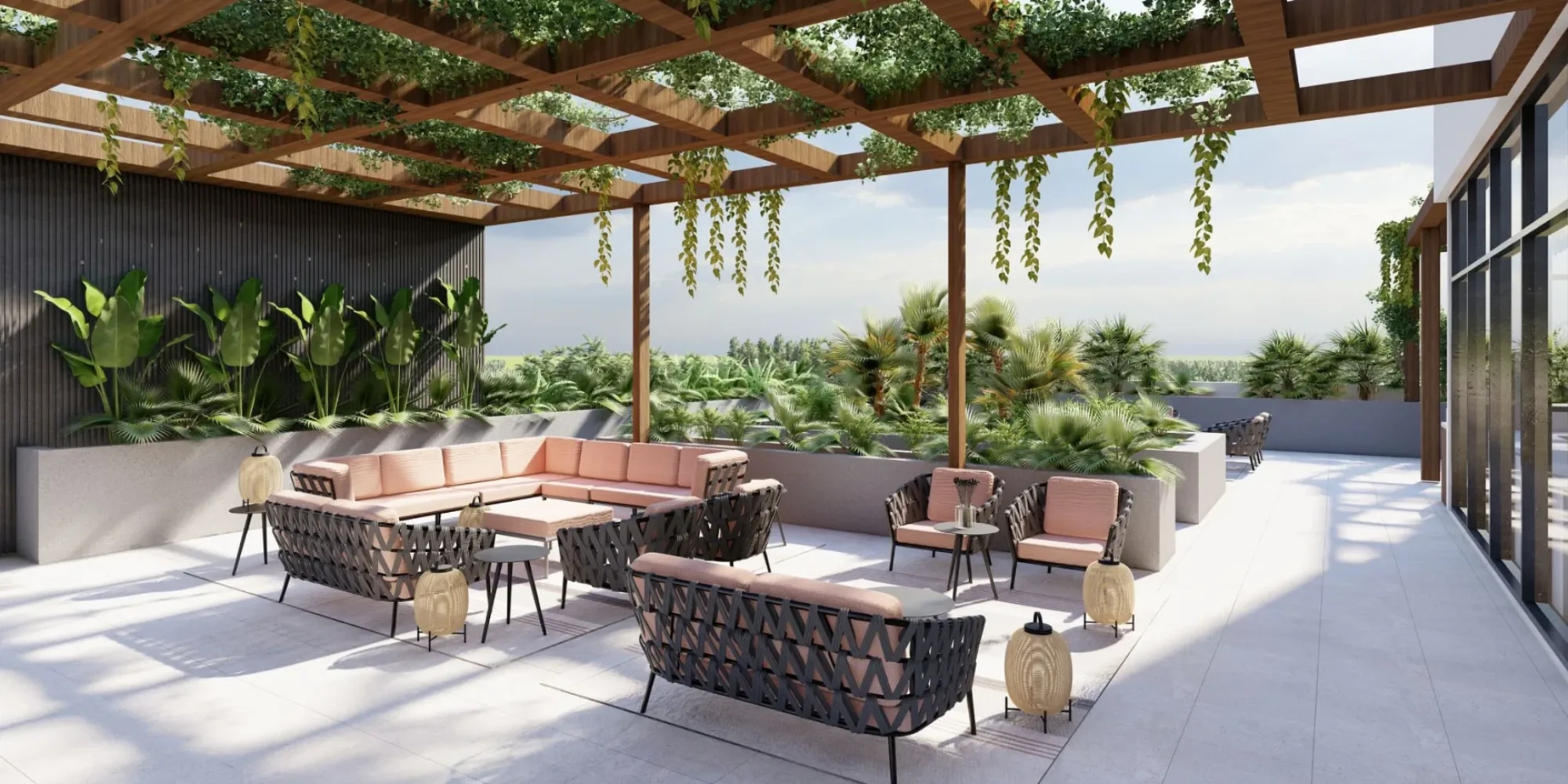 Outdoor Roof Terrace of the GNPC office design. The roof terrace consists of lounge chair and lounge sofas in grey rope structure and light pink cushions. Along with lounge furniture there are wicker lanterns also placed in the floor
