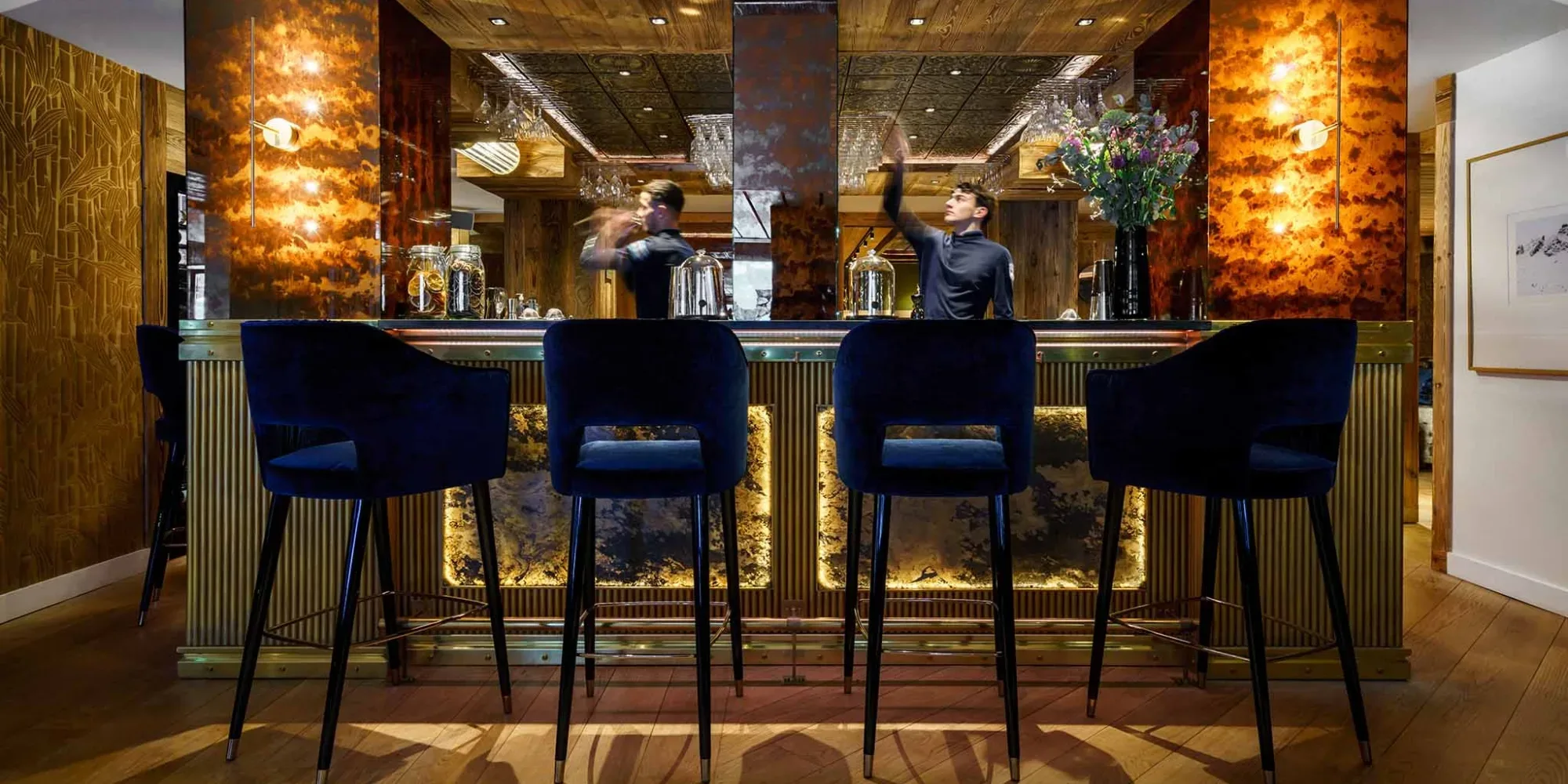 Bar Counter, La Sivoliere France consisting of custom barstools in blue velvet fabric and wooden base.
